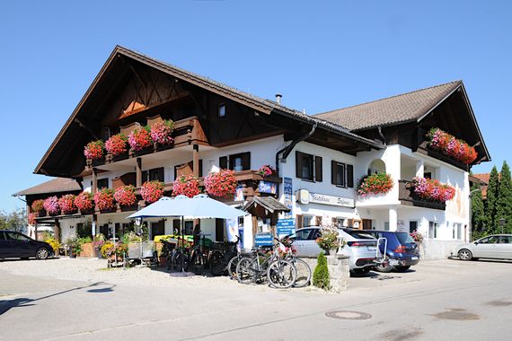 Guesthouse Stefanie in Brunnen with flower-filled balconies under a blue sky